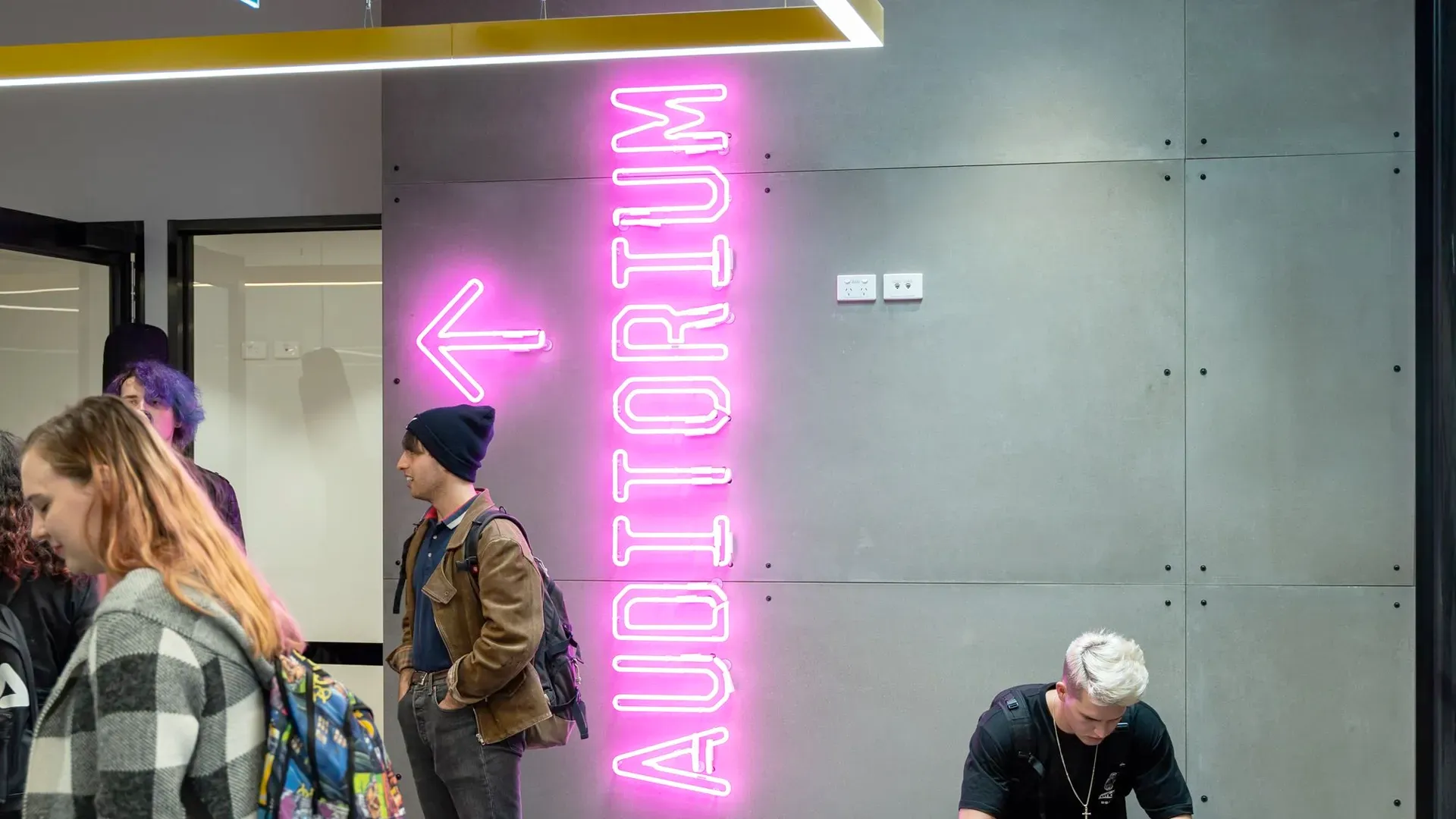 JMC auditorium neon sign with students