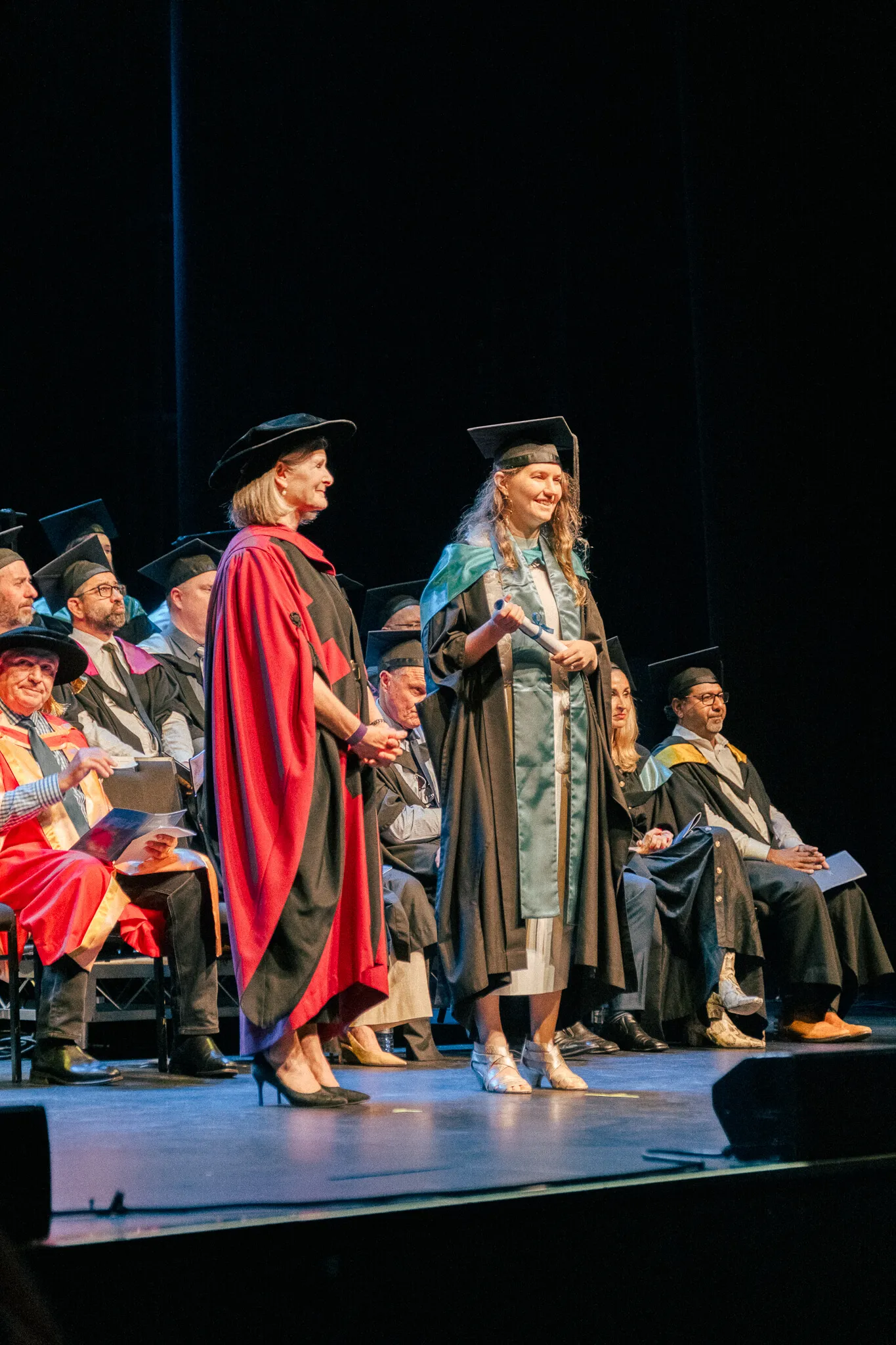 Group of JMC graduates celebrating together in front of a large creative installation