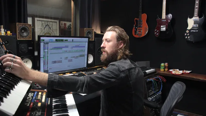 Music producer at workstation with guitars